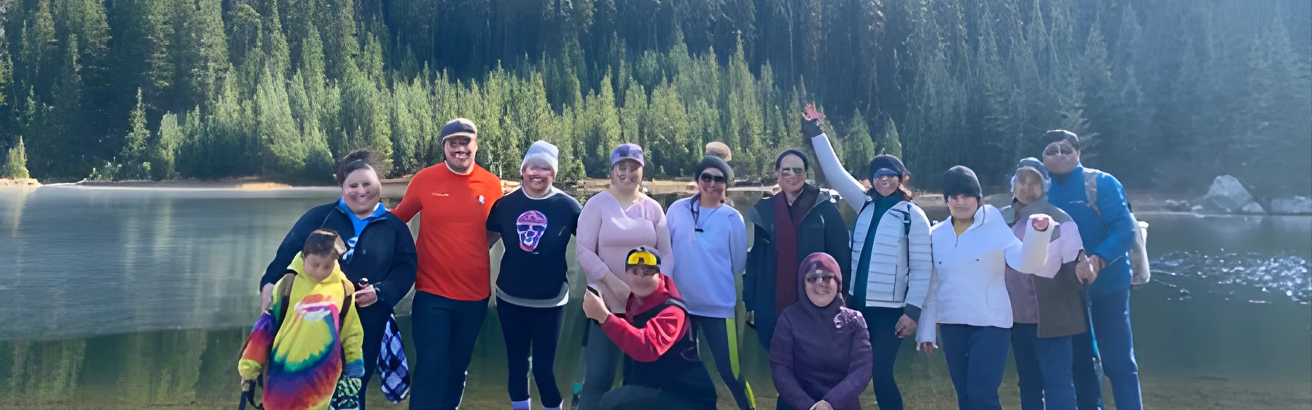 a group of people posing near a lake