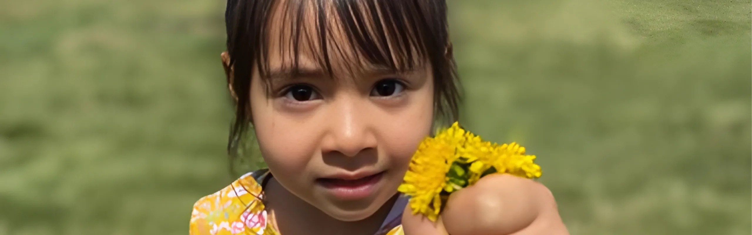 little girl offering a yellow flower