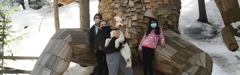 mother with two kids and a dog posing with the troll statue